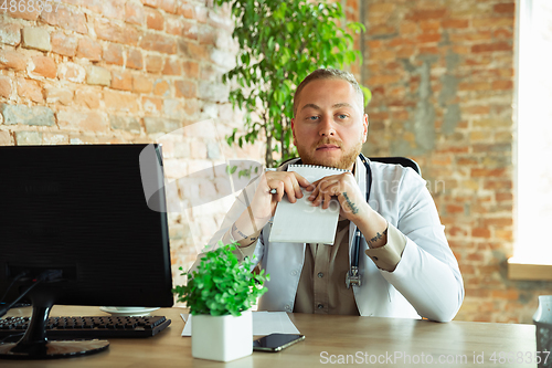 Image of Caucasian doctor consulting for patient, working in cabinet