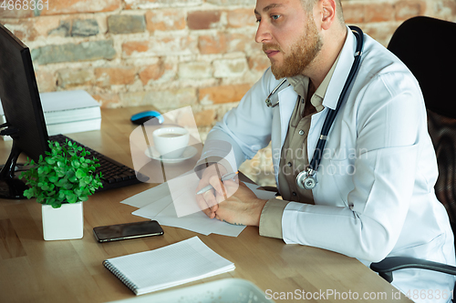 Image of Caucasian doctor consulting for patient, working in cabinet