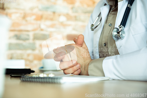 Image of Close up of caucasian doctor consulting for patient, explaining recipe for drug, working in cabinet