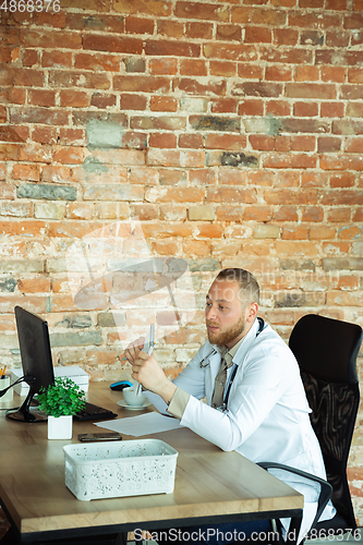 Image of Caucasian doctor consulting for patient, working in cabinet