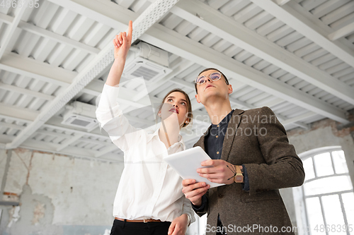 Image of Female estate agent showing new home to a young man after a discussion on house plans, moving, new home concept