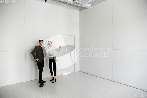 Image of Female estate agent showing new home to a young man after a discussion on house plans, moving, new home concept