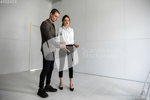 Image of Female estate agent showing new home to a young man after a discussion on house plans, moving, new home concept