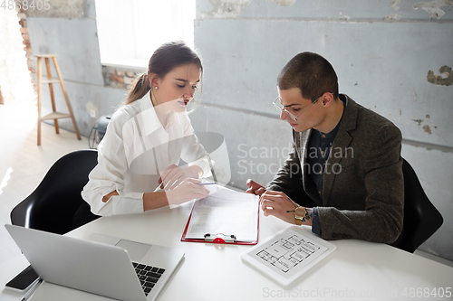 Image of Female estate agent showing new home to a young man after a discussion on house plans, moving, new home concept