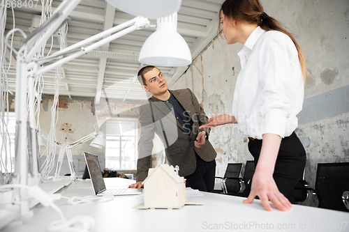 Image of Female estate agent showing new home to a young man after a discussion on house plans, moving, new home concept