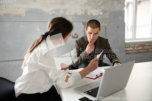 Image of Female estate agent showing new home to a young man after a discussion on house plans, moving, new home concept