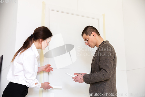 Image of Female estate agent showing new home to a young man after a discussion on house plans, moving, new home concept