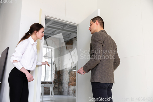 Image of Female estate agent showing new home to a young man after a discussion on house plans, moving, new home concept