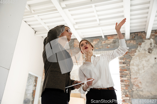 Image of Female estate agent showing new home to a young man after a discussion on house plans, moving, new home concept