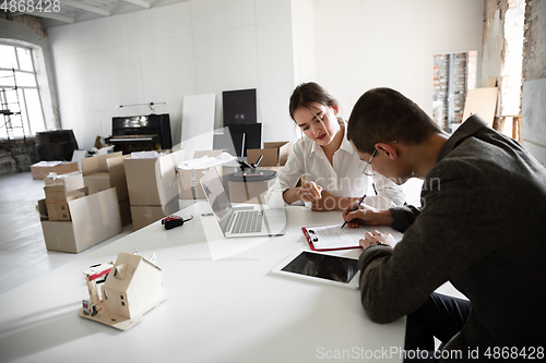 Image of Female estate agent showing new home to a young man after a discussion on house plans, moving, new home concept