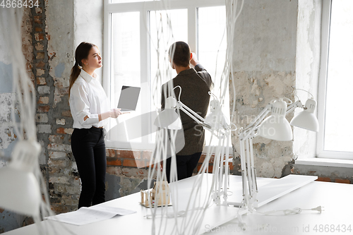 Image of Female estate agent showing new home to a young man after a discussion on house plans, moving, new home concept