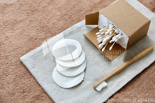 Image of wooden toothbrush, cotton pads and swabs in box