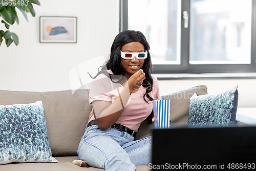 Image of happy african american woman watching tv at home