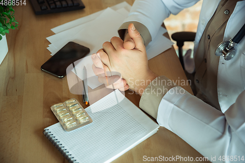 Image of Close up caucasian doctor consulting for patient, explaining recipe for drug, working in cabinet