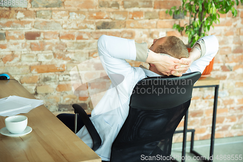 Image of Caucasian doctor resting after consulting for patient, working in cabinet