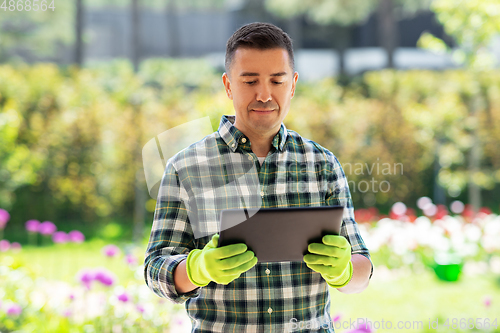 Image of man with tablet pc at summer garden