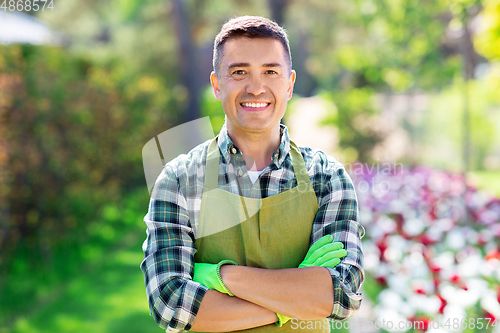 Image of happy man in apron at summer garden