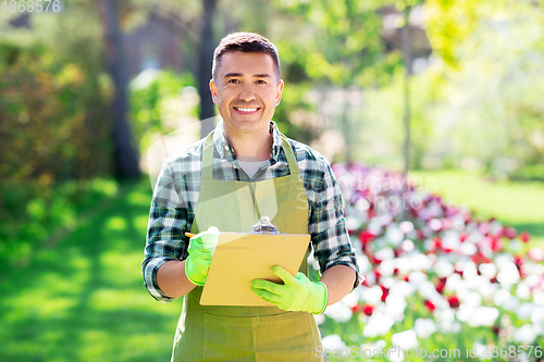 Image of happy man with clipboard at summer garden