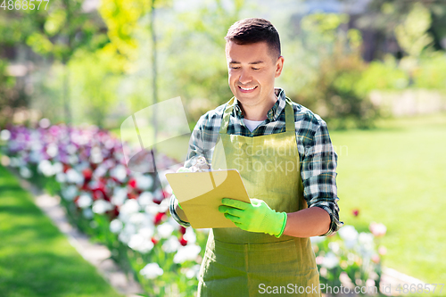 Image of happy man with clipboard at summer garden