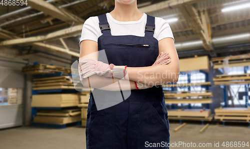 Image of close up of female worker in overall at factory