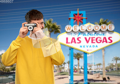 Image of man with vintage film camera over las vegas sign
