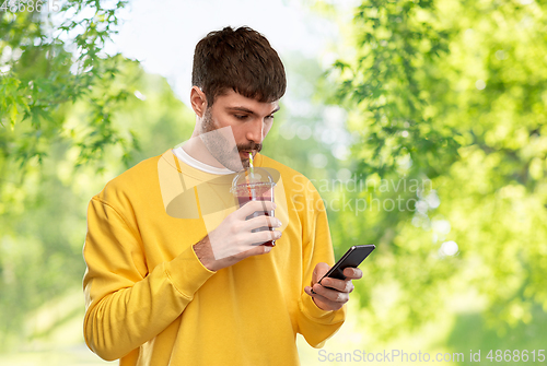 Image of man with smartphone and tomato juice