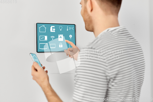 Image of man with smartphone and tablet pc at smart home