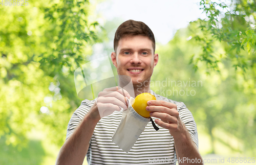 Image of smiling man with lemon in reusable canvas bag