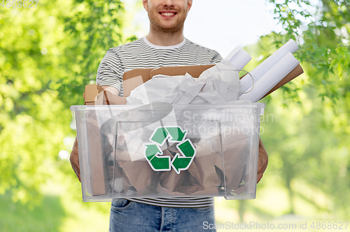 Image of smiling young man sorting paper waste