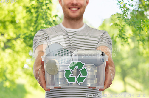 Image of smiling young man sorting metallic waste