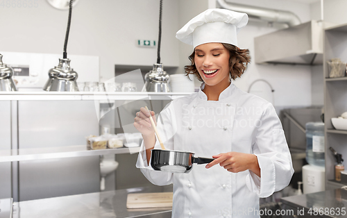 Image of happy smiling female chef with saucepan