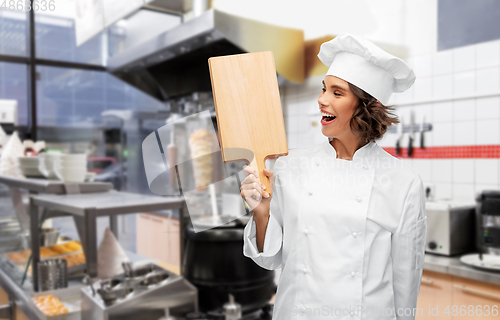 Image of happy female chef with cutting board at kebab shop