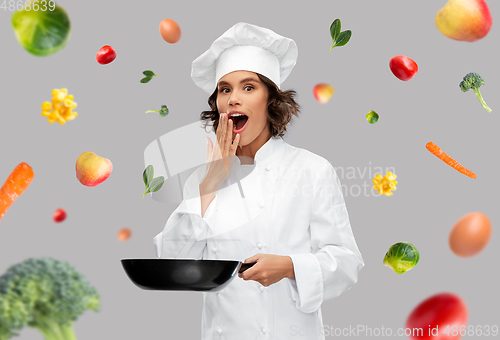 Image of surprised female chef with frying pan over food