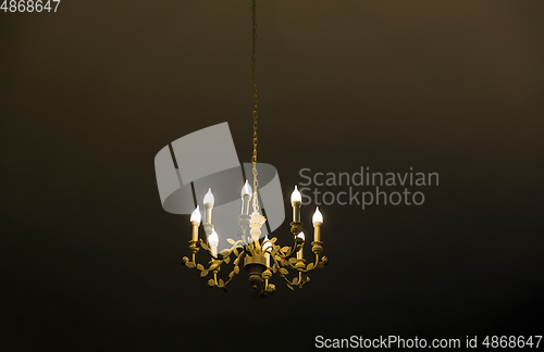 Image of ceiling lamp or chandelier hanging in dark room