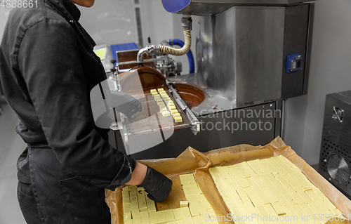 Image of worker processing candies at confectionery shop