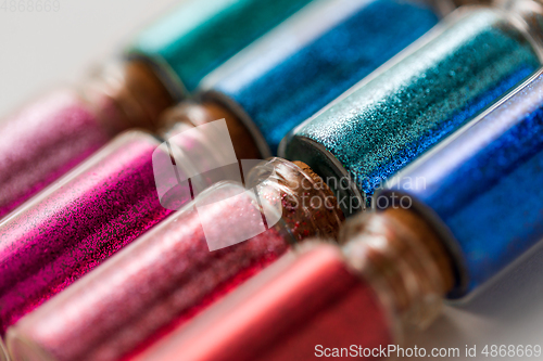 Image of set of glitters in bottles over white background