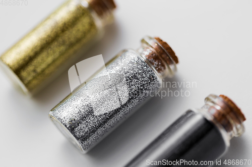 Image of set of glitters in bottles over white background