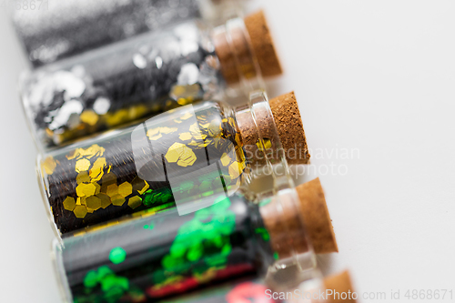 Image of set of glitters in bottles over white background