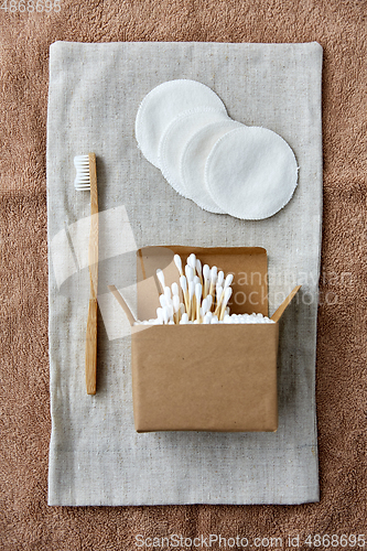 Image of wooden toothbrush, cotton pads and swabs in box