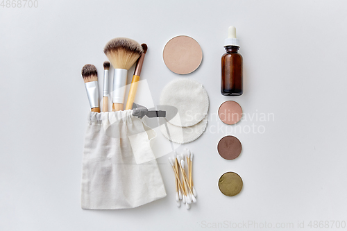 Image of make up brushes, cosmetics and cotton swabs