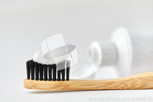 Image of natural wooden toothbrush with toothpaste on it