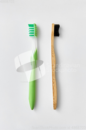 Image of wooden and plastic toothbrush on white background