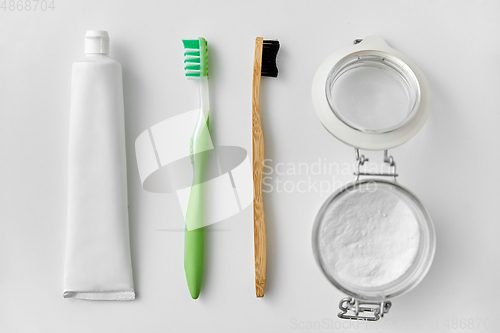 Image of toothbrushes, toothpaste and soda in jar