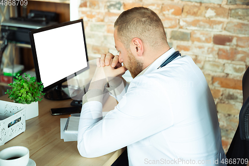 Image of Caucasian doctor resting after consulting for patient, working in cabinet