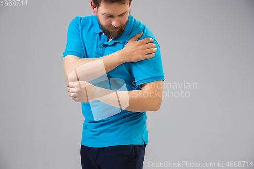 Image of Young man suffers from pain, feels sick, ill and weakness isolted on studio background