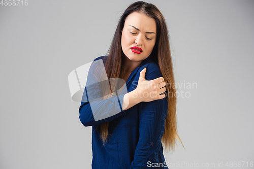 Image of Young woman suffers from pain, feels sick, ill and weakness isolted on studio background