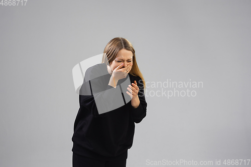 Image of Young woman suffers from pain, feels sick, ill and weakness isolted on studio background