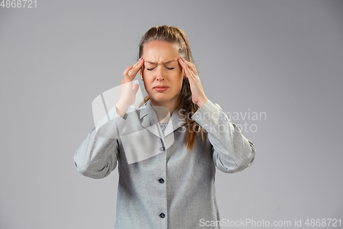 Image of Young woman suffers from pain, feels sick, ill and weakness isolted on studio background