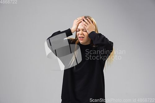 Image of Young woman suffers from pain, feels sick, ill and weakness isolted on studio background