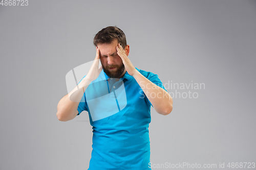 Image of Young man suffers from pain, feels sick, ill and weakness isolted on studio background